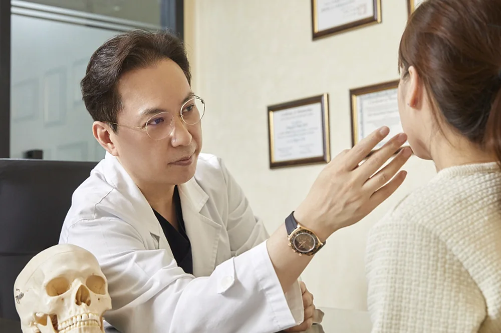 윤동주성형외과 원장님이 환자에게 얼굴 구조를 설명하는 상담 장면 — 크로스디자인 촬영